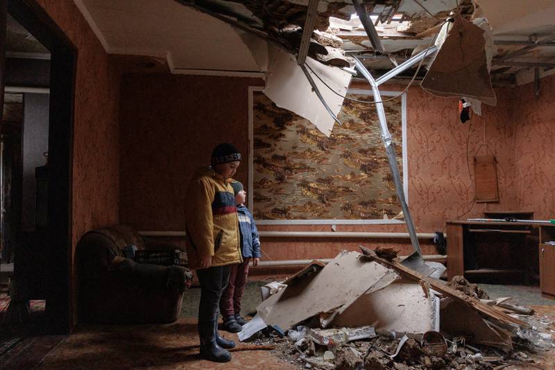 Marat and Renat Bonderenko in the living room of their neighbours' house, which was hit during Russia bombardment of the village of Yakovlivka outside Kharkiv, Ukraine. Reuters