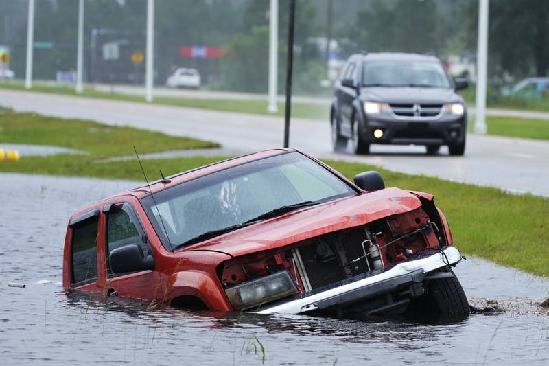 An abandoned vehicle is half submerged in a ditch in Bay Saint Louis. AP