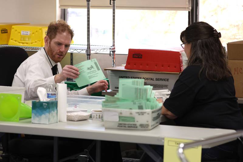Maricopa County recorder Stephen Richer, left, opens mail-in ballots at the Maricopa County Tabulation and Election Centre in Phoenix, Arizona. Ballots were being counted in Maricopa County three days after voters went to the polls for the midterm election in Arizona. AFP