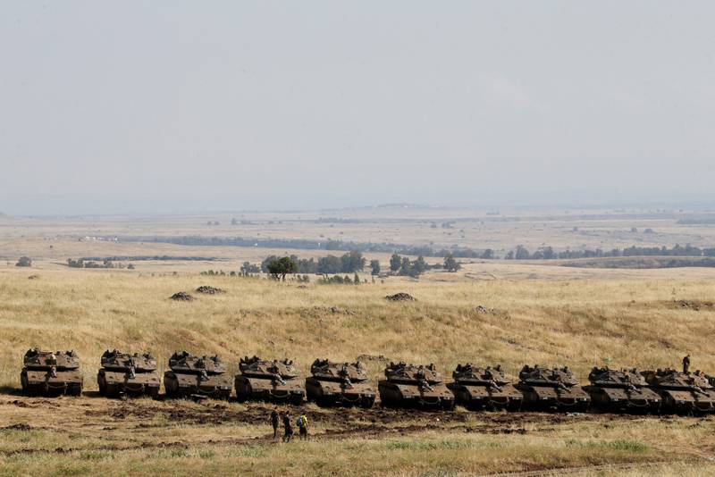 Israeli soldiers walk past tanks near the border with Syria in the Israeli-occupied Golan Heights, Israel May 11, 2018. REUTERS/Baz Ratner
