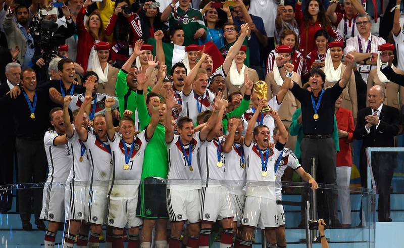 Germany's head coach Joachim Loew (2nd R) celebrates with his players after winning the 2014 FIFA World Cup final football match between Germany and Argentina 1-0 following extra-time at the Maracana Stadium in Rio de Janeiro, Brazil, on July 13, 2014. - Loew confirmed on July 12, 2016 that he will perform his contract with the German Football Federation (DFB) and stay as coach of the German national football team until the end of the Football World Cup to take place in the year 2018. (Photo by ODD ANDERSEN / AFP) / ALTERNATIVE CROP