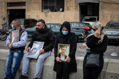 Kayan’s mother, holding a photograph of her son, Mohammed, sits outside the port of Beirut on the sixth-month anniversary of the explosion.