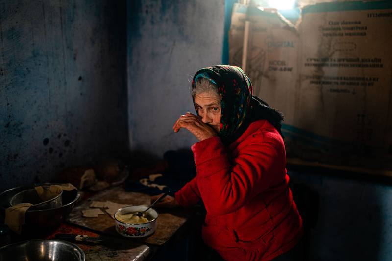 A Ukrainian woman prepares food amid power shortages in the village of Posad-Pokrovs'ke, near the front of the war with Russia in the country's Kherson region. AFP