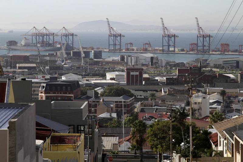 The residential district of Woodstock overlooks gantry cranes on the harbourside in the commercial port area of Cape Town, South Africa, on Wednesday, April 24, 2013. South Africa's gross domestic product is forecast to expand 2.6 percent this year, compared with 2.5 percent in 2012, according to the country's central bank. Photographer: Nadine Hutton/Bloomberg