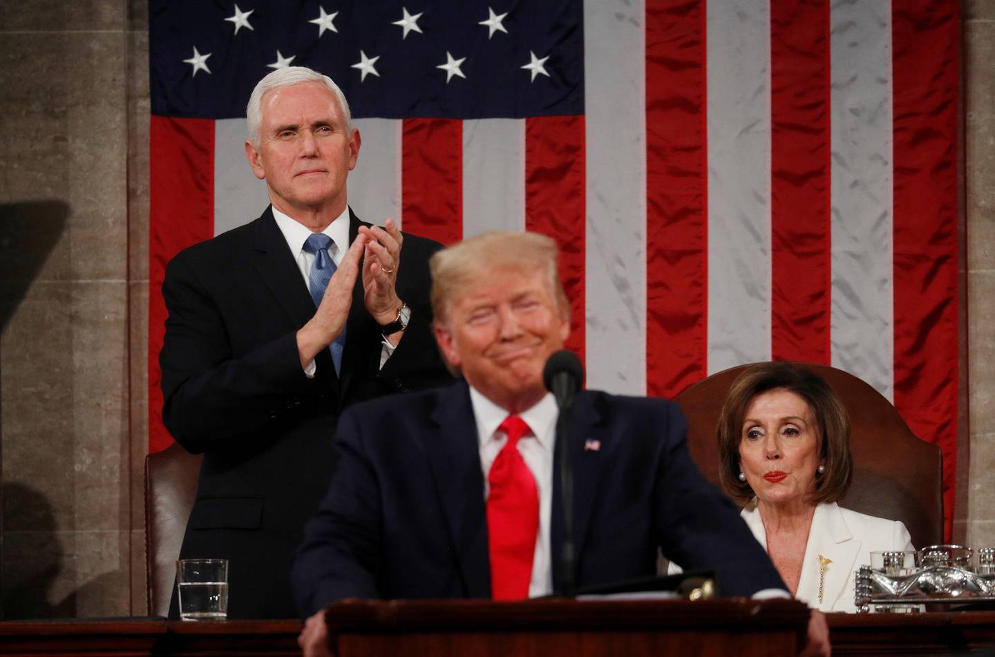 U.S. Vice President Mike Pence stands and applauds as Speaker of the House Nancy Pelosi reacts to President Donald Trump as he delivers his State of the Union address to a joint session of the U.S. Congress in the House Chamber of the U.S. Capitol in Washington, U.S. February 4, 2020. REUTERS/Leah Millis/POOL     TPX IMAGES OF THE DAY