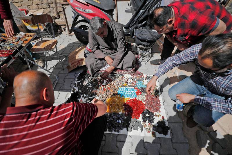 Customers buy loose gemstones from a street seller at Tahrir Square market, Baghdad. AFP