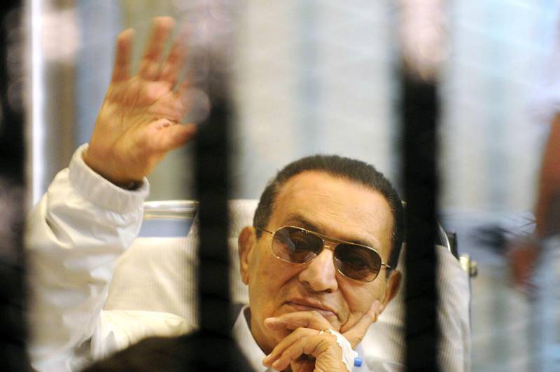 FILE - In this April 13, 2013 file photo, former Egyptian President Hosni Mubarak waves to his supporters from behind bars as he attends a hearing in his retrial on appeal in Cairo, Egypt. Egypt's state TV said Tuesday, Feb. 25, 2020, that the country's former President Hosni Mubarak, ousted in the 2011 Arab Spring uprising, has died at 91. Mubarak, who was in power for almost three decades, was forced to resign on Feb. 11, 2011, after following 18 days of protests around the country. The Arab Spring uprisings had convulsed autocratic regimes across the Middle East. (AP Photo, File)