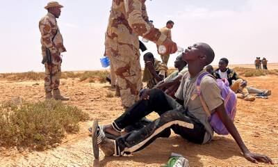 A Libyan border guard provides water to a migrant abandoned by Tunisian authorities in an uninhabited area on the Libya-Tunisia border near Al Assah. EPA