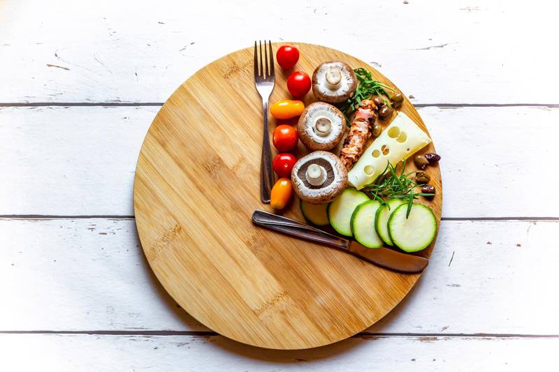 Vegetables on round chopping board, symbol for intermittent fasting. Getty Images