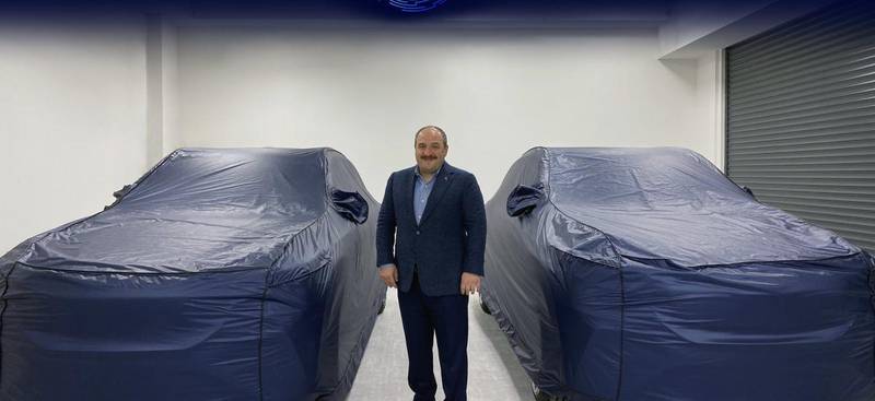 Mustafa Varank, Minister of Industry and Technology, poses with Turkey's new electric car, set to be unveiled on Friday. Courtesy: Turkish Ministry of Industry and Technology Twitter