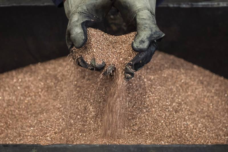 A worker handles copper shavings at a foundry. Bloomberg