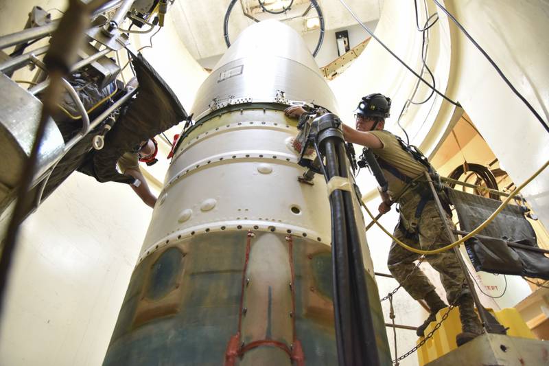 Technicians connect a re-entry system to a spacer on an intercontinental ballistic missile. AP