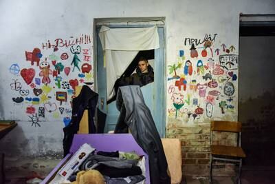 Local youth Vladyslav, 17, inspects the basement of the school building in Yahidne. EPA
