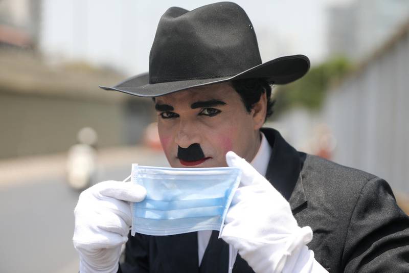 A Charlie Chaplin impersonator performs to spread awareness about wearing a mask, on the occasion of Chaplin's birthday, amidst the spread of COVID-19, on a street in Mumbai, India. REUTERS / Francis Mascarenhas