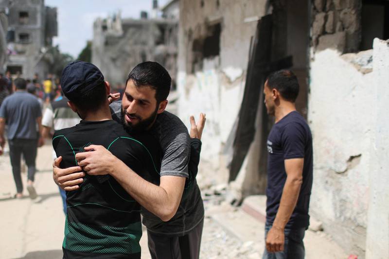 Palestinians hug each other after returning to their destroyed houses following the Israel-Hamas truce, in Beit Hanoun in the northern Gaza Strip. Reuters