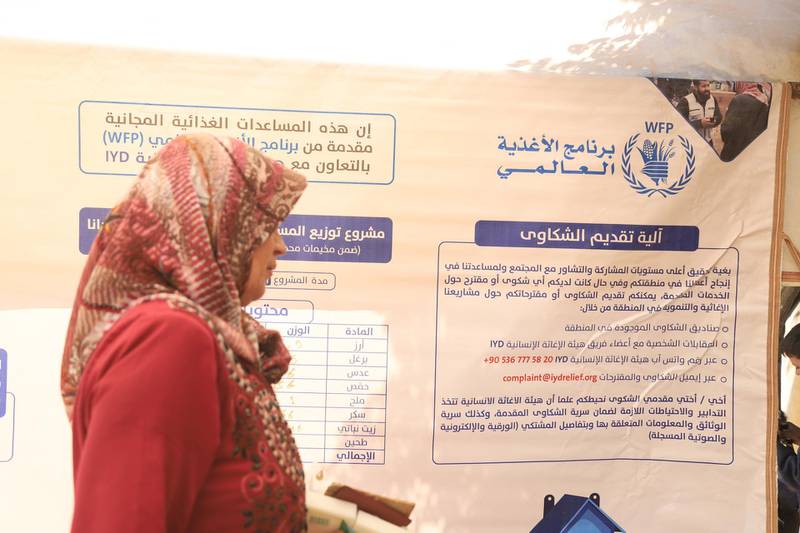 2.	One of the beneficiaries in waiting room going to to authentication room holding legal documents, a banner appears with the project details mentioned on.