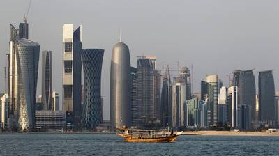 FILE - In this Thursday Jan. 6, 2011 file photo, a traditional dhow floats in the Corniche Bay of Doha, Qatar, with tall buildings of the financial district in the background. Qatar has hired a Washington influence firm founded by President Donald Trump's former campaign manager and another specialized in digging up dirt on U.S. politicians. (AP Photo/Saurabh Das, File)