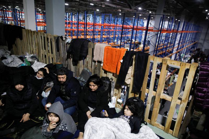 Migrants set up beds in the transport and logistics centre. Reuters