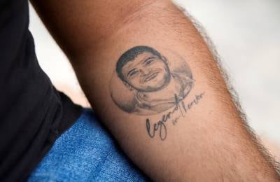 A tattoo on Roy Samaha's arm shows a picture of his late cousin Joe Noun, a firefighter who was a victim of last year's Beirut port blast, in Beirut, Lebanon.