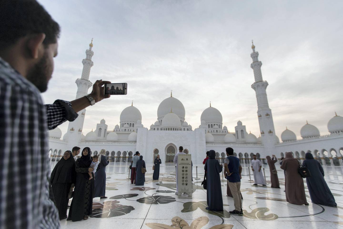 Abu Dhabi, United Arab Emirates, August 31, 2017:    A tourist takes a picture with a smartphone as the sun sets over Sheikh Zayed Grand Mosque ahead of Eid al-Adha in Abu Dhabi on August 31, 2017. Eid al-Adha, or the, Feast of the Sacrifice, honors the willingness of Ibrahim to sacrifice his son Ismaeel, as an act of obedience to God's command. Christopher Pike / The National

Reporter:  N/A
Section: News