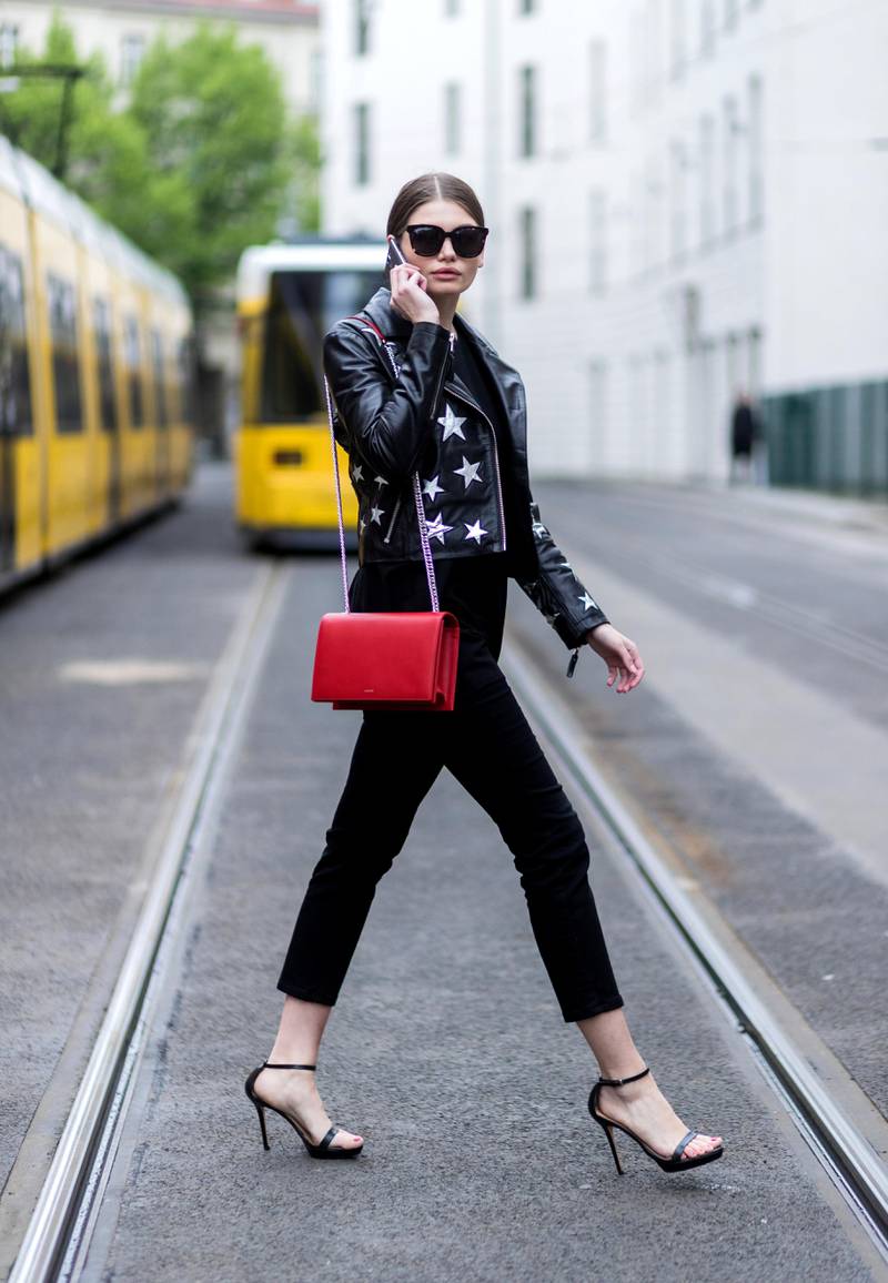 BERLIN, GERMANY - MAY 5: Maxilie Mlinarskij on the phone wearing a black Be Edgy Berlin leather jacket with start print, red Agneel bag, black sunglasses Gentle Monster, Zara heeled sandals, black top on May 5, 2017 in Berlin, Germany. (Photo by Christian Vierig/Getty Images)