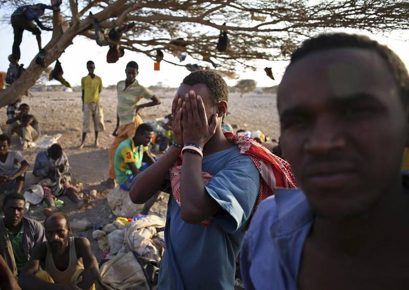 A man from Ethiopia covers his face as he waits with other illegal immigrants for a boat to cross into Yemen outside the town of Obock, in north Djibouti. Goran Tomasevic / Reuters / February 22, 2015