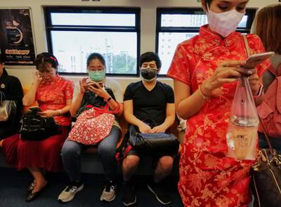 People wearing face masks ride in a train in Bangkok, Thailand. AFP