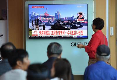 People watch a television news reporting a parade marking the 70th anniversary of the foundation of North Korea held in Pyongyang.  AFP