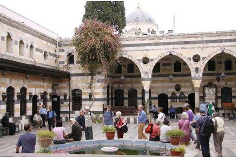 Tourists walk around Al Azem Palace, which houses the museum of arts and popular traditions in the Old City of Damascus, Syria.