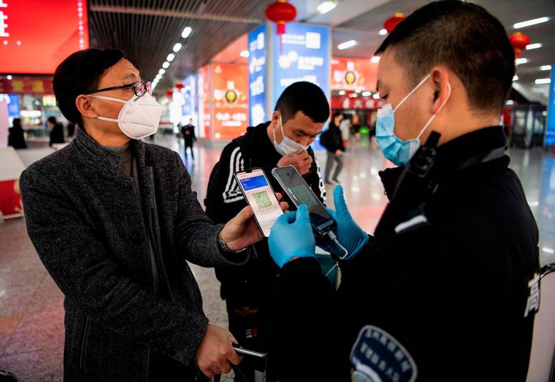 A passenger wearing a face mask as he shows a green QR code on his phone to show his health status to security upon arrival at Wenzhou railway station in Wenzhou. The National Health Commission on March 1 reported 573 new infections, bringing the total number of cases in mainland China to 79,824. AFP