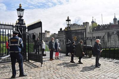 Members of the public, some wearing face coverings, queue to enter the re-opened Tower of London. AFP