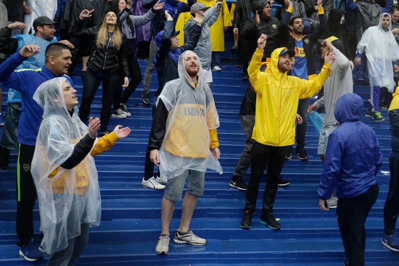 Fans of Argentina's Boca Juniors cheer under the rain. AP Photo