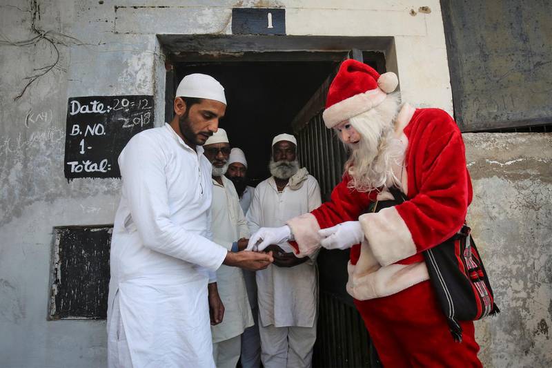 A person dressed as Santa Claus distributes sweets to inmates during Christmas celebrations inside Kot Bhalwal jail, on the outskirts of Jammu, India. REUTERS
