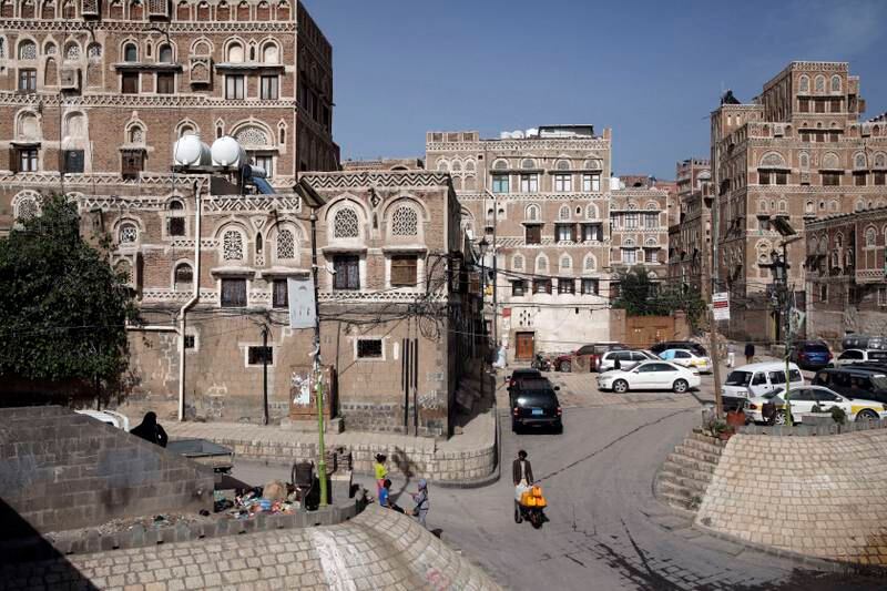 Yemenis walk past historic buildings in Sanaa, Yemen, in early April. EPA