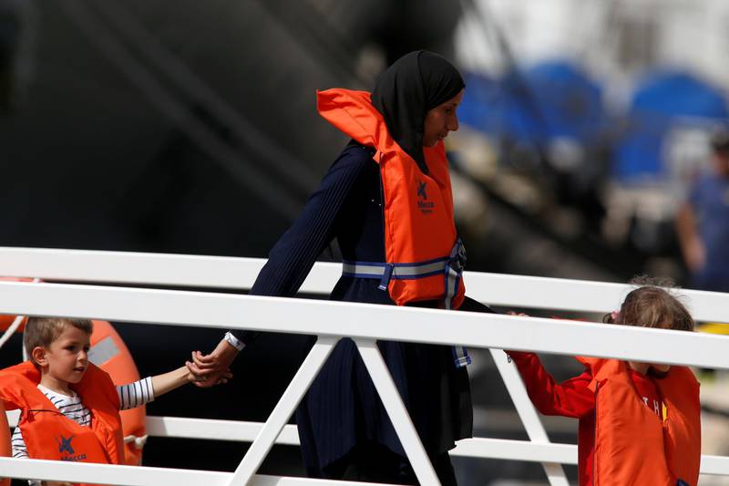 Migrants from the German rescue ship "Alan Kurdi" disembark from an Armed Forces of Malta vessel after arriving at its base in Marsamxett Harbour, Valletta, Malta July 9, 2019. REUTERS/Darrin Zammit Lupi