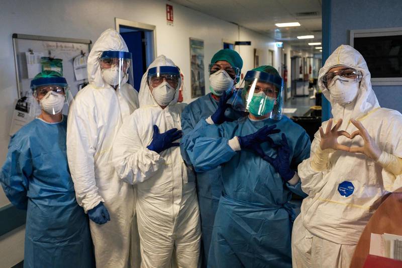 A group of nurses wearing protective gear pose for a group photo prior to their night shift at the Cremona hospital, southeast of Milan. AFP
