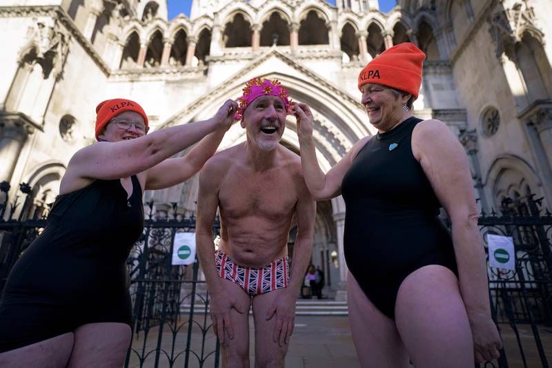 Swimmers from Hampstead Ponds outside the Royal Courts of Justice, London, on Wednesday, as they await the result of a judicial review over whether the charges for bathing at the ponds in Hampstead Heath, London, unlawfully discriminate against disabled people. PA