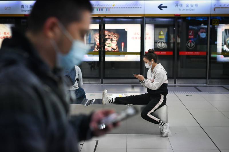 A woman uses her mobile phone at a subway station in Beijing. AFP