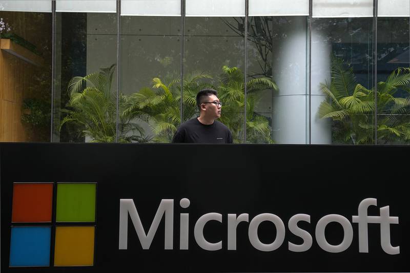A man stands outside the Microsoft office building in Beijing. The company's sales during the third quarter jumped 18 per cent to almost $49.4 billion. AP