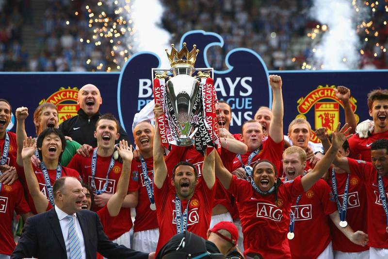 WIGAN, UNITED KINGDOM - MAY 11:  Ryan Giggs of Manchester United  lifts the Barclays Premier League trophy as his team mates celebrate following their victory at the end of the Barclays Premier League match between Wigan Athletic and Manchester United at The JJB Stadium on May 11, 2008 in Wigan, England.  (Photo by Alex Livesey/Getty Images)