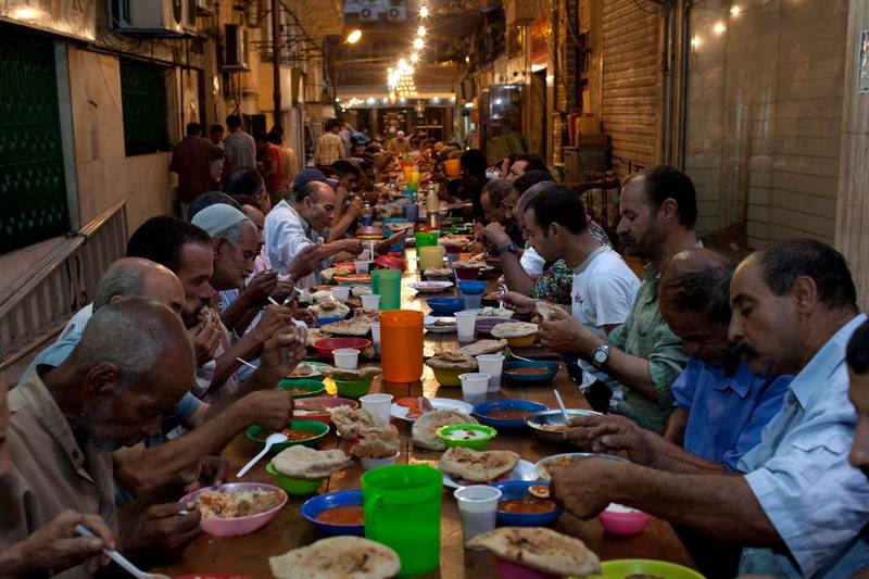 Poor Egyptians enjoy a free iftar on a street in the Zamalek district of Cairo August 14, 2010. During Ramadan, wealthy individuals, charitable organizations and mosques traditionally distribute food to the poor. (Photo by Scott Nelson, for the National)