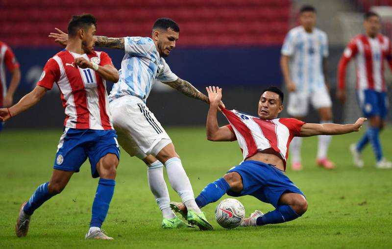 Paraguay's Angel Romero (L) and Alejandro Romero challenge Leandro Paredes (C) for the ball. AFP