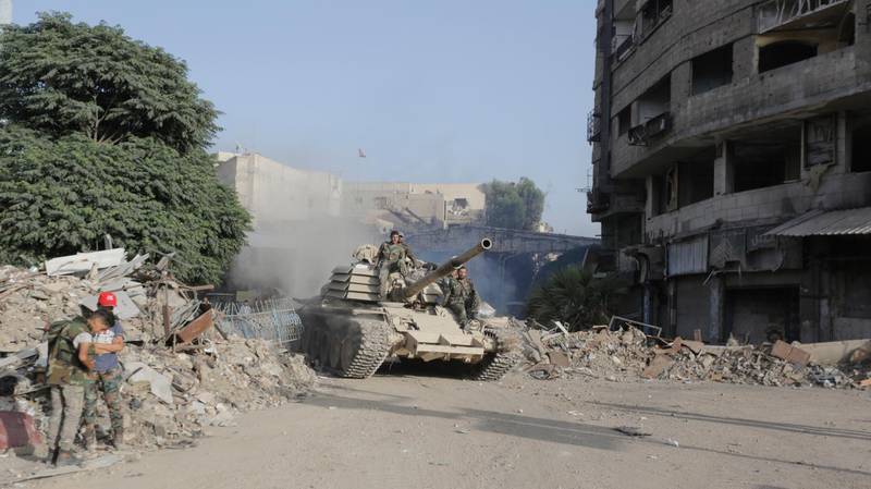epa06754747 Soldiers ride atop a tank in destoyed parts of the Yarmouk camp neighborhood in south Damascus, Syria, 21 May 2018. According to reports, the Syrian army claims it has regained full control over Damascus' surrounding areas. State TV reports that the army cleared the area and the adjacent al-Yarmouk camp after killing large number of ISIS fighters.  EPA/YOUSSEF BADAWI