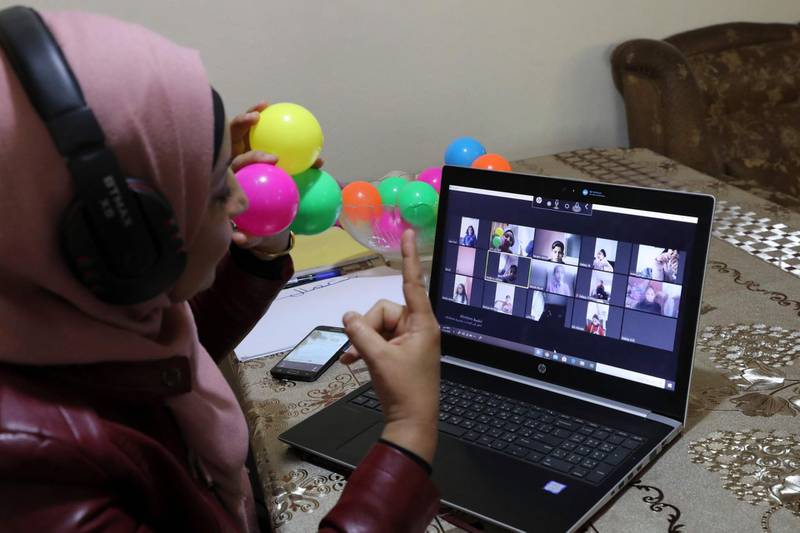 This picture taken on March 23, 2020 shows Palestinian teacher Jihad Abu Sharar presenting an online class from her home in the village of Dura near Hebron in the occupied West Bank, after schools were closed as a preventive measure against the spread of the COVID-19 novel coronavirus.  / AFP / Hazem BADER

