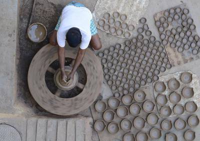 Indian potter Chelimila Veera Swamy makes earthen pots or 'diyas' ahead of the forthcoming Diwali festival on the outskirts of Hyderabad.  Noah Seelam / AFP