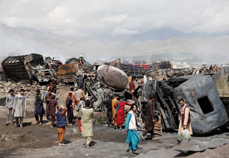 Men walk amidst wreckages of fuel tankers and trucks after an overnight fire, on the outskirts of Kabul. Reuters