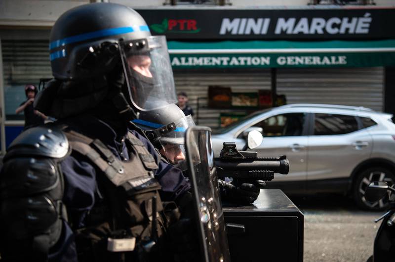 A police officer holds a rubber bullet gun amid clashes with protesters on International Workers' Day, in Paris. AFP