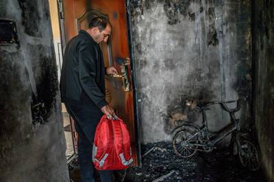 Razim Mehmedov, 40, holding his daughter's backpack stands in his flat that was damaged and burnt by shelling as residents return to their homes after a ceasefire in the military conflict between Armenia and Azerbaijan over the breakaway region of Nagorno-Karabakh, in the town of Terter, Azerbaijan. AFP