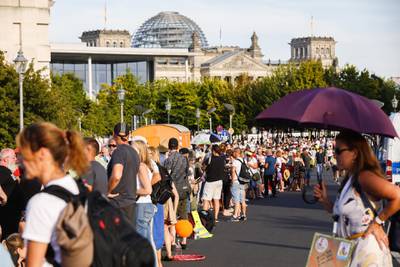 Demonstrators coming from a rally stand nearby the Reichstag building, the seat of the German parliament, following a protest against coronavirus pandemic regulations in Berlin, Germany.  EPA