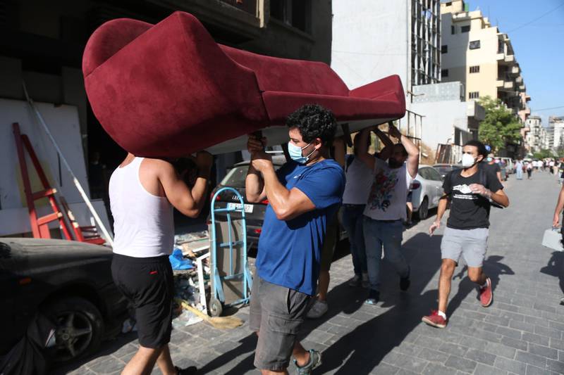 Lebanese youth salvage a velvet sofa from a destroyed apartment in the Gemayzeh area of Beirut.  EPA